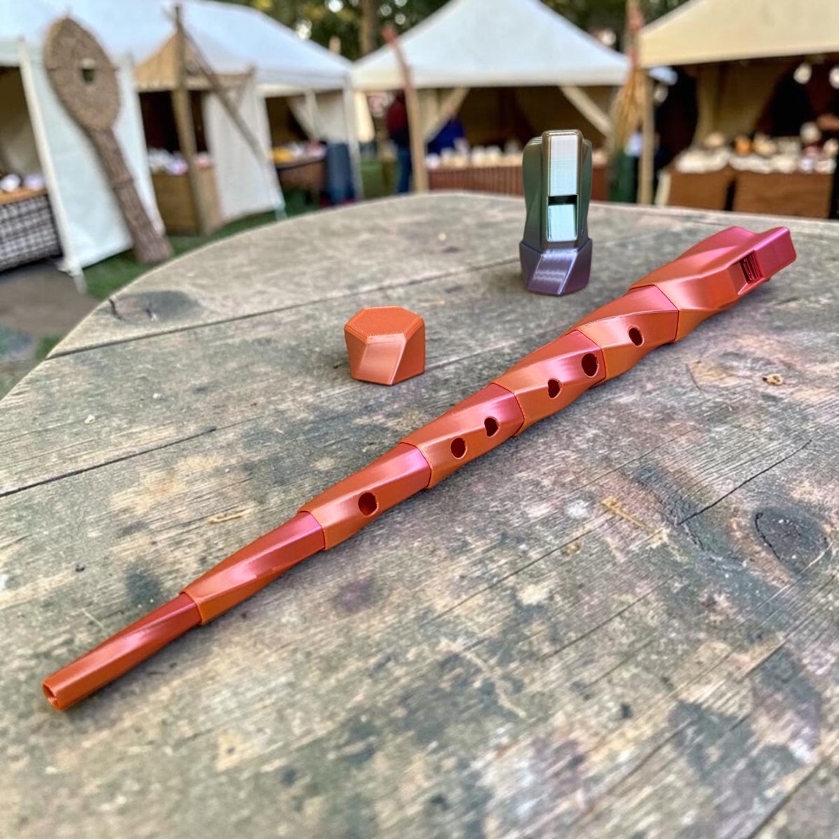 HPHobbies custom printed metallic copper flute with ergonomic design on a wooden table at an outdoor market